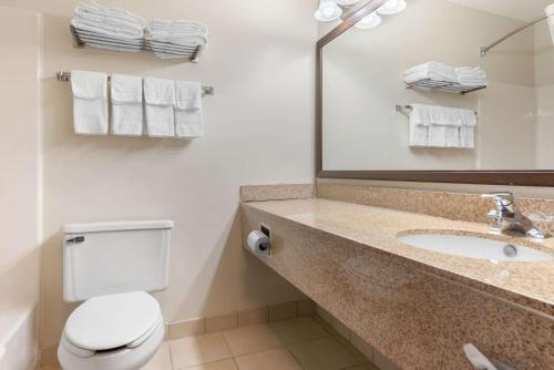 a bathroom with a sink and a toilet and a mirror at Quality Inn in Fairborn
