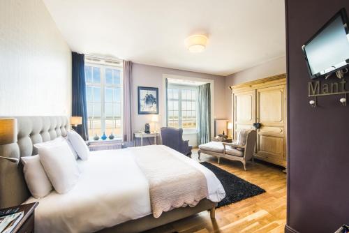 ヴィムルーにあるLa Goélette, Chambres d'Hôtesのベッドとテレビが備わるホテルルームです。