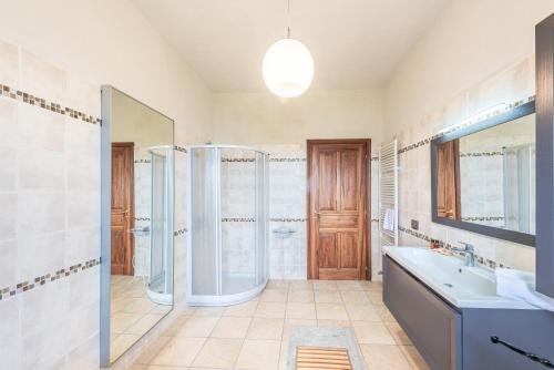 ein Bad mit einer Dusche, einem Waschbecken und einem Spiegel in der Unterkunft Villa Bricco Paglieri, entire Villa in Alba