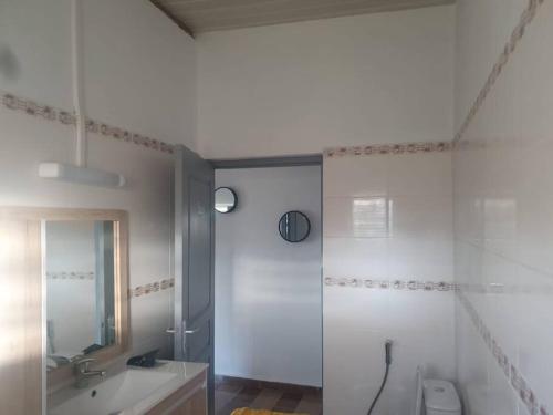 uma casa de banho com um chuveiro, um WC e um lavatório. em T3 haut standing avec accès & parking privé em Bandraboua