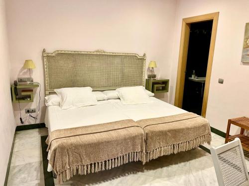 Postel nebo postele na pokoji v ubytování Hotel Conde de Cárdenas