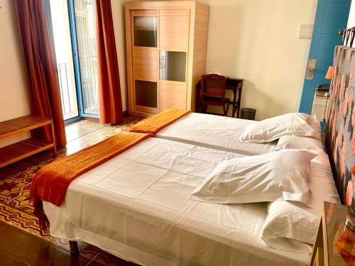 Postel nebo postele na pokoji v ubytování Hotel Conde de Cárdenas