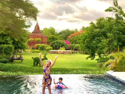 a woman and a child in a pool of water at The Hotel Umbra Bagan in Bagan