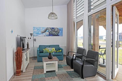 a living room with a blue couch and chairs at RCN Vakantiepark Bungalow de Dukdalf in Kamperland