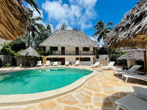a swimming pool in front of a villa at Oleza Boutique Hotel Zanzibar in Michamvi