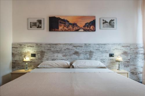 a bedroom with a white bed and two lamps at Residenza Sant'Anna in Cuggiono