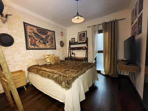 a bedroom with a bed and a flat screen tv at Villa Atlántida. Precioso apartamento con ventanas al mar in Santa Maria de Guia de Gran Canaria