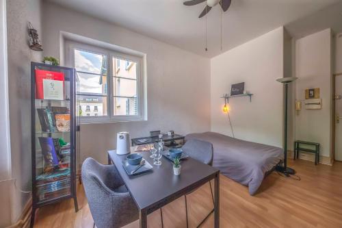 un salon avec une table et un lit dans l'établissement Agréable T1 (3 étoiles) face au parc de Uriage-Les-Bains, à Vaulnaveys-le-Haut