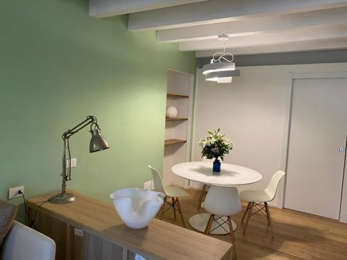 Le Vele Carloforte في كارلوفورتي: غرفة طعام مع طاولة وطاولة وكراسي بيضاء