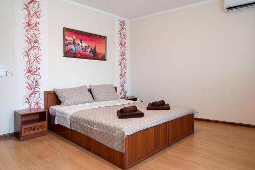 Un dormitorio con una cama con dos zapatos marrones. en Apartment Veda, en Veliko Tŭrnovo