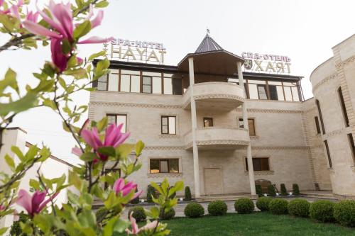 皮亞季戈爾斯克的住宿－哈亞特Spa酒店，前面有粉红色花的建筑