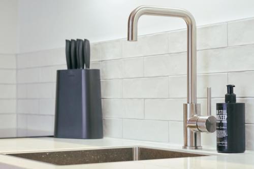 a kitchen counter with a sink and a faucet at RITCH Hotel Alkmaar in Alkmaar