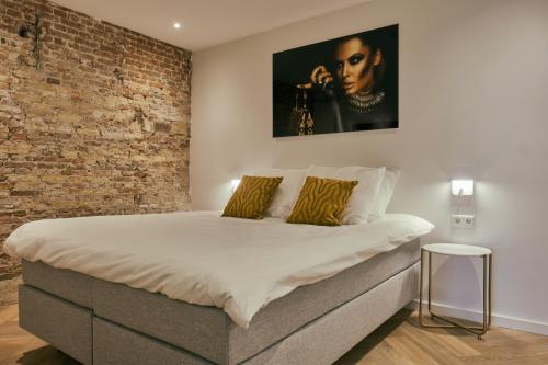 een slaapkamer met een bed met een bakstenen muur bij RITCH Hotel Alkmaar in Alkmaar