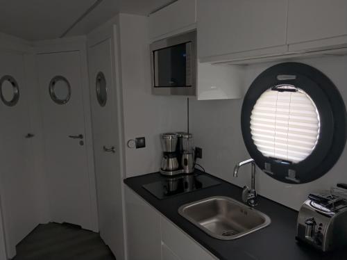 a small kitchen with a sink and a window at Ostsee Hausboot Schleswig Ostseeblick 1 in Schleswig