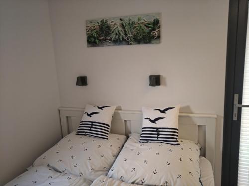 two beds in a bedroom with two pillows at Ostsee Hausboot Schleswig Ostseeblick 1 in Schleswig