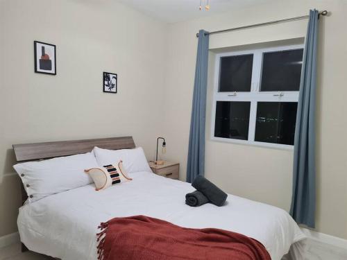 um quarto com uma grande cama branca e uma janela em Lofts 2B/R Lounge with City Views, Gym, Tennis Court em Kingston