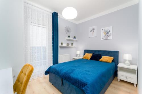 a bedroom with a blue bed and a window at Apartament Eveline in Rzeszów