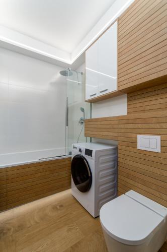 a bathroom with a washing machine and a toilet at Apartament Eveline in Rzeszów
