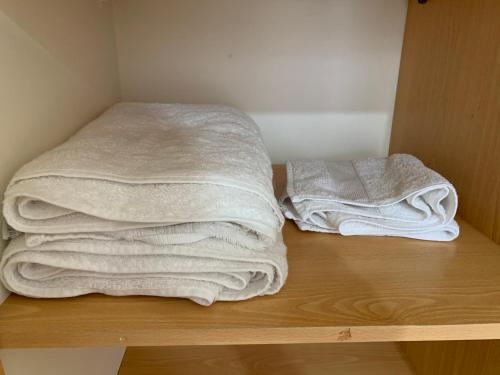 two stacks of towels sitting on a wooden shelf at Magnolia apart Con facturas in Iquique