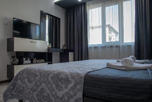a bedroom with a bed with a television and towels on it at Apartment Central-LUX 1 in Veliko Tŭrnovo