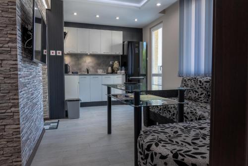 ヴェリコ・タルノヴォにあるApartment Central-LUX 1のガラスのテーブル付きのキッチンが備わる客室です。