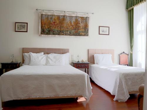 a bedroom with two beds with white sheets at Alegre - Bussaco Boutique Hotel in Luso