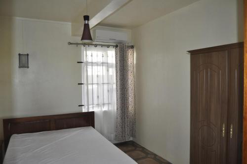 a bedroom with a bed and a window at Moringi (Veer Residences) in Trou dʼ Eau Douce