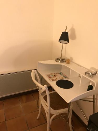uma secretária branca com um candeeiro e uma cadeira em Domaine Trevinella em Cauro