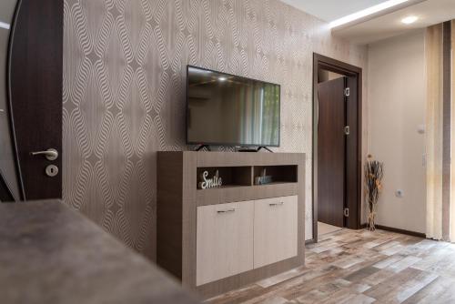een woonkamer met een flatscreen-tv aan de muur bij Apartment Central-LUX in Veliko Tŭrnovo