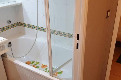 une baignoire blanche avec douche dans une salle de bain dans l'établissement Charmant T2 de 34m2 en Résidence de standing à Grimaud - Piscines - Jardinet - Plein coeur du Golfe de St Tropez- Pleine nature, à Grimaud