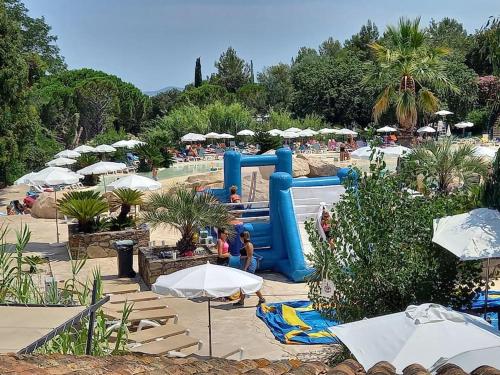 un parc aquatique avec un toboggan et des parasols dans l'établissement Charmant T2 de 34m2 en Résidence de standing à Grimaud - Piscines - Jardinet - Plein coeur du Golfe de St Tropez- Pleine nature, à Grimaud