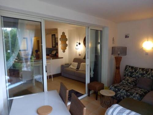 un salon avec un canapé et une table dans l'établissement Charmant T2 de 34m2 en Résidence de standing à Grimaud - Piscines - Jardinet - Plein coeur du Golfe de St Tropez- Pleine nature, à Grimaud