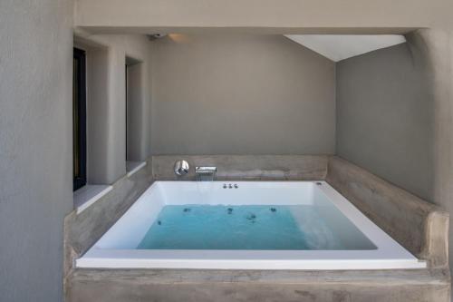 a bath tub in a room with a tub at Christianna & George Luxury Hot Tub Apartment in Fira