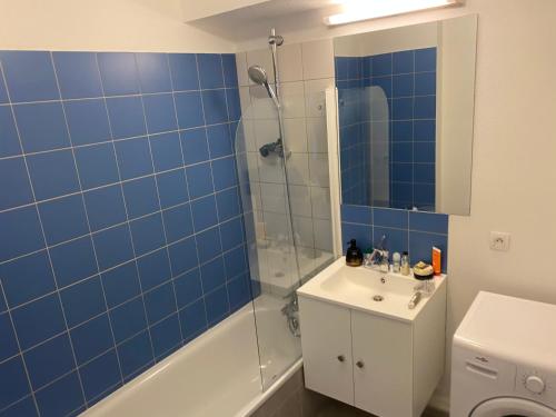 a bathroom with a sink and a shower with blue tiles at LE VELODROME Chic appartement in Marseille