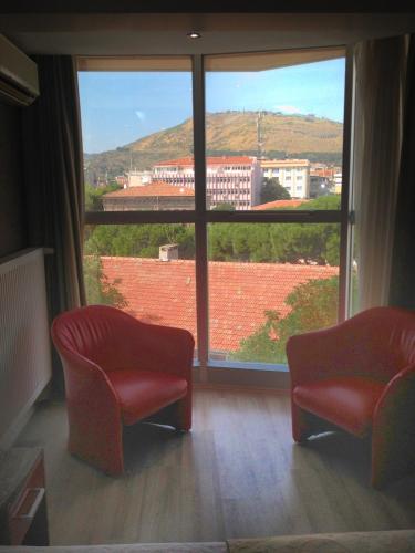 sala de estar con 2 sillas y ventana grande en Anil Hotel, en Bergama