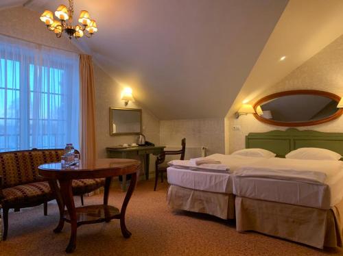 a hotel room with two beds and a table at Hotel Usadba in Kaliningrad