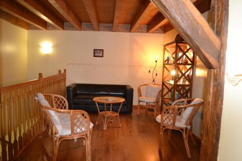 a living room with a couch and chairs and a table at Chambres d'Hôtes Le Moulin à Epices in Chargey-lès-Gray