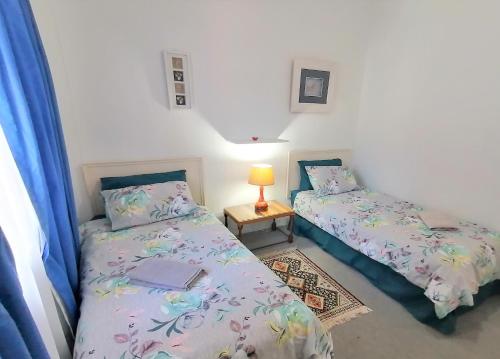 um quarto com 2 camas e uma mesa com um candeeiro em Summer Rocks A em Margate