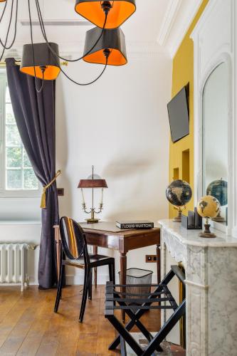 a room with a desk and a table with chairs at L'Hôtel Particulier - Paris Asnières in Asnières-sur-Seine