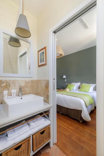 a bathroom with a sink and a bed and a mirror at L'Hôtel Particulier - Paris Asnières in Asnières-sur-Seine