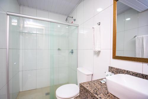 a bathroom with a toilet and a sink and a mirror at Hotel Dan Inn Express Salvador in Salvador