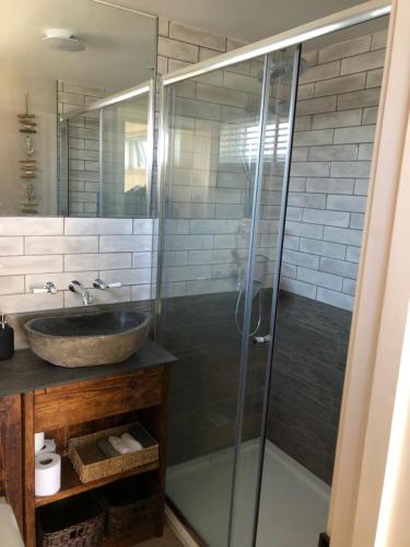 een badkamer met een wastafel en een glazen douche bij Piala retreat in Phillack