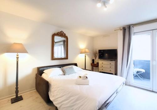 une chambre avec un grand lit et un miroir dans l'établissement Viva Riviera Residence Palazzio Cannes, à Cannes