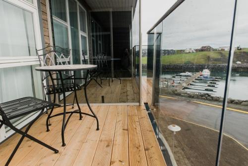 a balcony with a table and chairs and a window at Hotel Duus by Keflavik Airport in Keflavík