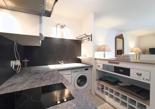 une cuisine avec un évier et une machine à laver dans l'établissement Viva Riviera Residence Palazzio Cannes, à Cannes