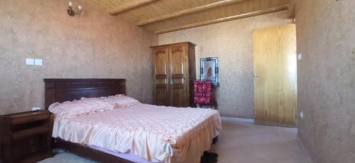 1 dormitorio con 1 cama y puerta de madera en Brothers house 4, en Imsouane