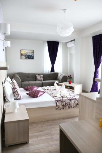 a bedroom with a large bed and a couch at Kharisma Hotel in Mamaia Sat/Năvodari