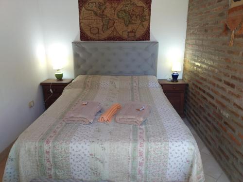 a bedroom with a bed with two towels on it at Abuelo Coqui in Ramallo