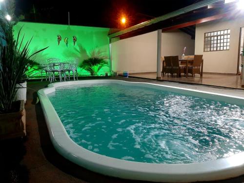 una piscina por la noche con mesa y sillas en Recanto Rafaella, en Olímpia