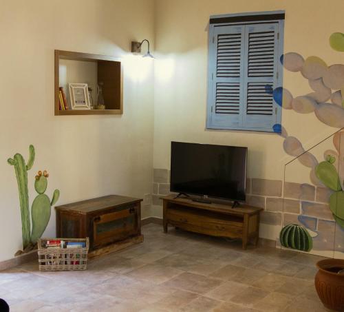 Una sala de estar con un televisor de pantalla plana en una pared. en Anima Sicula, en Agrigento
